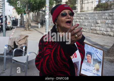 Jérusalem, Israël . Dec 25, 2013. VARDA AKIVA, mère de assassiné Shaltiel Akiva (1964-1985), porte une photo de son fils comme elle proteste à l'extérieur de la résidence du premier ministre contre la libération des prisonniers palestiniens. Jérusalem, Israël. 25-Dec-2013. Israël à libérer les prisonniers palestiniens, parmi eux les meurtriers condamnés avec "du sang sur les mains", dans ce qui est considéré comme une 'troisième impulsion' dans le cadre du processus de négociations de paix. Credit : Alon Nir/Alamy Live News Banque D'Images