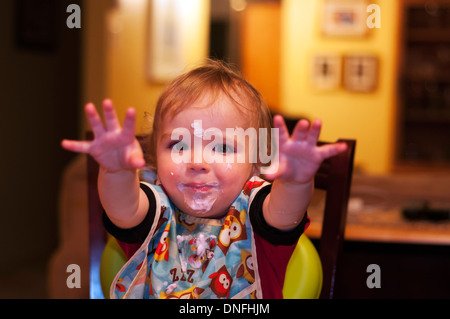 Un petit garçon avec du yogourt sur son visage Banque D'Images