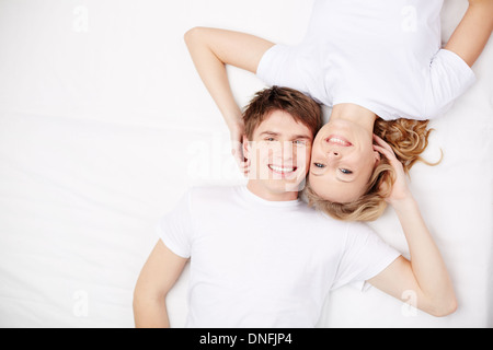 Deux happy young girls in Lying in Bed and looking at camera Banque D'Images