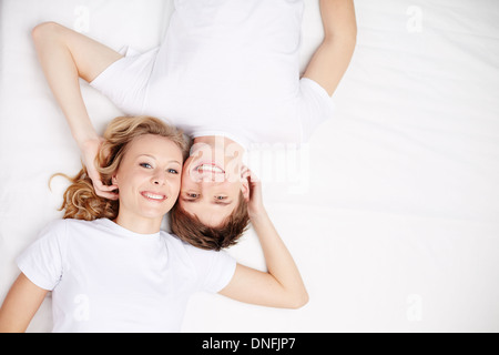 Deux happy young girls in Lying in Bed and looking at camera Banque D'Images