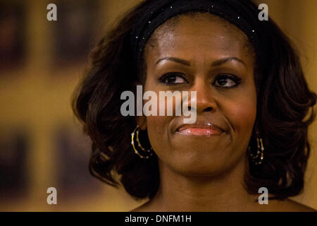 La baie de Kaneohe, Hawaii, USA. Le 25 décembre 2013. La Première Dame Michelle Obama écoute que son mari, le président des États-Unis, Barack Obama, parle aux membres de l'armée américaine et leurs familles qu'ils mangent un repas le jour de Noël dans le hall Anderson au mess de la Base Marine Corps Hawaii à Kaneohe Bay à Kaneohe, Hawaii, USA, le 25 décembre 2013. Credit : Kent Nishimura / Piscine via CNP/dpa/Alamy Live News Banque D'Images