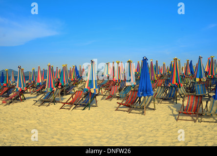 Locations de chaises longues et parasols sur la plage de sable de l'île tropicale de la Thaïlande Banque D'Images