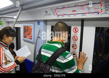 Beijing Chine,chinois,métro,train,passagers rider riders,riders,homme asiatique hommes,adulte,adulte,femme femme femme,Airport Express train,L Banque D'Images