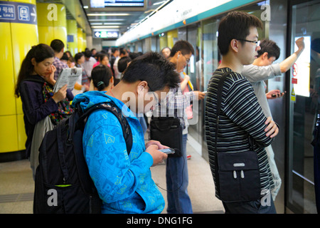 Beijing Chine,Chinois,Dongzhimen Station de métro,passagers rider riders,rider,homme asiatique hommes,ligne 2,plate-forme,attente,smartphone cellule pho Banque D'Images