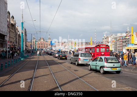 Rue Damrak le trafic dans le centre-ville d'Amsterdam, la gare centrale à l'extrémité, la Hollande, les Pays-Bas. Banque D'Images