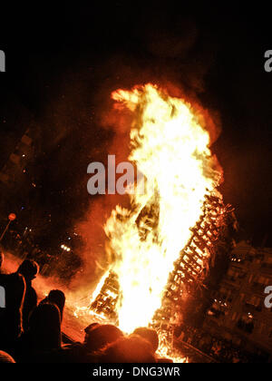 Thessalonique, Grèce. Le 24 décembre, 2013. Les gens qui regardent le grand incendie dans le centre de Florina. La veille de Noël de la ville de Florina en Grèce du Nord et les villages environnants une tradition particulière se fait appelé ' ? ?les incendies' ?ÃƒÂ¹. Au cours de cet événement les habitants des grands incendies dans chaque partie de la ville. Cette tradition est dit que éloigne les mauvais esprits et symbolise les bergers qui visitent le nouveau-né le Christ. L'éclat de l'incendie devrait réchauffer l'enfant. Autour du feu, les habitants et les touristes de la danse, de boire du vin et manger de la soupe de haricots.Photo : Giannis Papanikos/NurPhoto (crédit Image : © Gian Banque D'Images