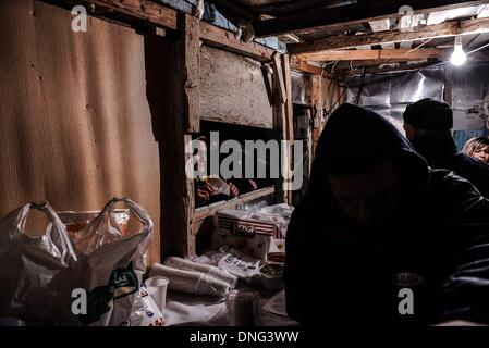 Thessalonique, Grèce. Le 24 décembre, 2013. Servir de soupe aux haricots et du vin avant la veille de Noël.La veille de Noël de la ville de Florina en Grèce du Nord et les villages environnants une tradition particulière se fait appelé ãƒæ'Ã'àƒ¢â''àƒ ?š š ?l''firesÃƒAE'Ã'Â'''Àƒæ Sàƒæ ?š Â''. Au cours de cet événement les habitants des grands incendies dans chaque partie de la ville. Cette tradition est dit que éloigne les mauvais esprits et symbolise les bergers qui visitent le nouveau-né le Christ. L'éclat de l'incendie devrait réchauffer l'enfant. Autour du feu, les habitants et les touristes de la danse, de boire du vin et manger de la soupe de haricots.Photo : Giannis Papanikos/Nu Banque D'Images