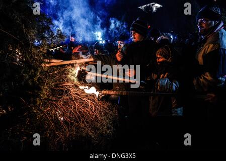 Thessalonique, Grèce. Le 24 décembre, 2013. Les enfants ont mis le feu à l'arbre pendant la veille de Noël. La veille de Noël de la ville de Florina en Grèce du Nord et les villages environnants une tradition particulière se fait appelé ãƒæ'Ã'àƒ¢â''àƒ ?š š ?l''firesÃƒAE'Ã'Â'''Àƒæ Sàƒæ ?š Â''. Au cours de cet événement les habitants des grands incendies dans chaque partie de la ville. Cette tradition est dit que éloigne les mauvais esprits et symbolise les bergers qui visitent le nouveau-né le Christ. L'éclat de l'incendie devrait réchauffer l'enfant. Autour du feu, les habitants et les touristes de la danse, de boire du vin et manger de la soupe de haricots.Photo : Giannis Papan Banque D'Images