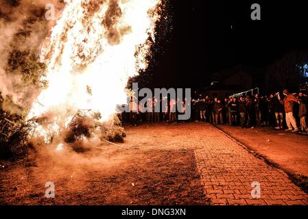 Thessalonique, Grèce. Le 24 décembre, 2013. Les gens autour du feu pendant la veille de Noël. La veille de Noël de la ville de Florina en Grèce du Nord et les villages environnants une tradition particulière se fait appelé ãƒæ'Ã'àƒ¢â''àƒ ?š š ?l''firesÃƒAE'Ã'Â'''Àƒæ Sàƒæ ?š Â''. Au cours de cet événement les habitants des grands incendies dans chaque partie de la ville. Cette tradition est dit que éloigne les mauvais esprits et symbolise les bergers qui visitent le nouveau-né le Christ. L'éclat de l'incendie devrait réchauffer l'enfant. Autour du feu, les habitants et les touristes de la danse, de boire du vin et manger de la soupe de haricots.Photo : Giannis Papanikos/NurPho Banque D'Images