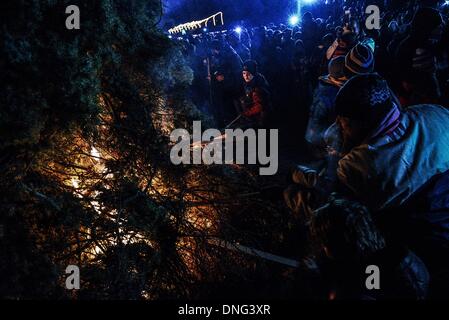 Thessalonique, Grèce. Le 24 décembre, 2013. Les enfants ont mis le feu à l'arbre pendant la veille de Noël. La veille de Noël de la ville de Florina en Grèce du Nord et les villages environnants une tradition particulière se fait appelé ãƒæ'Ã'àƒ¢â''àƒ ?š š ?l''firesÃƒAE'Ã'Â'''Àƒæ Sàƒæ ?š Â''. Au cours de cet événement les habitants des grands incendies dans chaque partie de la ville. Cette tradition est dit que éloigne les mauvais esprits et symbolise les bergers qui visitent le nouveau-né le Christ. L'éclat de l'incendie devrait réchauffer l'enfant. Autour du feu, les habitants et les touristes de la danse, de boire du vin et manger de la soupe de haricots.Photo : Giannis Papan Banque D'Images