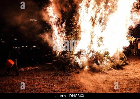 Thessalonique, Grèce. Le 24 décembre, 2013. Les gens autour du feu pendant la veille de Noël. La veille de Noël de la ville de Florina en Grèce du Nord et les villages environnants une tradition particulière se fait appelé ãƒæ'Ã'àƒ¢â''àƒ ?š š ?l''firesÃƒAE'Ã'Â'''Àƒæ Sàƒæ ?š Â''. Au cours de cet événement les habitants des grands incendies dans chaque partie de la ville. Cette tradition est dit que éloigne les mauvais esprits et symbolise les bergers qui visitent le nouveau-né le Christ. L'éclat de l'incendie devrait réchauffer l'enfant. Autour du feu, les habitants et les touristes de la danse, de boire du vin et manger de la soupe de haricots.Photo : Giannis Papanikos/NurPho Banque D'Images