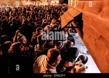 Thessalonique, Grèce. Le 24 décembre, 2013. Des centaines de personnes en attente d'être servis et le vin soupe de haricots pendant la veille de Noël. La veille de Noël de la ville de Florina en Grèce du Nord et les villages environnants une tradition particulière se fait appelé ãƒæ'Ã'àƒ¢â''àƒ ?š š ?l''firesÃƒAE'Ã'Â'''Àƒæ Sàƒæ ?š Â''. Au cours de cet événement les habitants des grands incendies dans chaque partie de la ville. Cette tradition est dit que éloigne les mauvais esprits et symbolise les bergers qui visitent le nouveau-né le Christ. L'éclat de l'incendie devrait réchauffer l'enfant. Autour du feu, les habitants et les touristes de la danse, de boire du vin et manger bean pour Banque D'Images