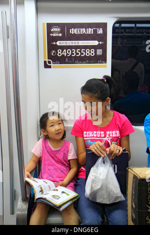 Beijing Chine,Chinois,Dongzhimen Station de métro,ligne 2 13,passagers rider riders,riders,cabine de train,asiatique adulte,adultes,femme femme femme,m Banque D'Images