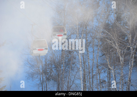 Deux gondoles ascenseur skieurs et planchistes au sommet de la montagne sur une froide journée d'hiver à Mont-Tremblant, Québec Banque D'Images