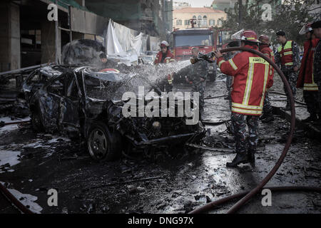 Beyrouth, Liban. Dec 27, 2013. Un pompier brûlé libanais éteint les véhicules sur les lieux d'une explosion. Mohammad Chatah, ancien ministre libanais et de l'opposition, a été tué vendredi dans l'explosion alors que son convoi traversait le centre-ville de Beyrouth. © Hasan Shaaban/NurPhoto ZUMAPRESS.com/Alamy/Live News Banque D'Images