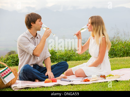 Beau couple drinking champagne on pique-nique après-midi romantique en campagne Banque D'Images