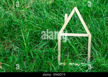 Maison modèle faite de bâtonnets de bois sur l'herbe verte Banque D'Images