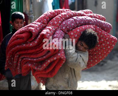 Kaboul, Afghanistan. 28 Dec, 2013. Un garçon Afghan porte quilt donnés par le gouvernement allemand pour les personnes déplacées à Kaboul, Afghanistan, le 28 décembre 2013. © Ahmad Massoud/Xinhua/Alamy Live News Banque D'Images