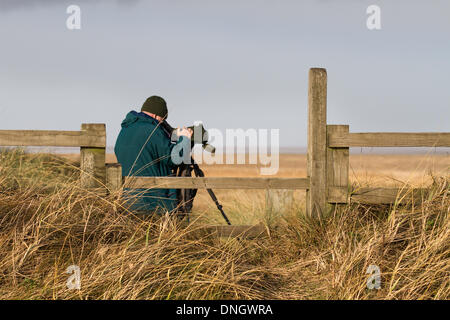 Observation des oiseaux, ou observation des oiseaux, ornithologues, jumelles d'observation de la faune, lunettes, optique, trépieds à Southport, Merseyside, Royaume-Uni. 29 décembre 2013. Observateurs d'oiseaux surveillant les espèces migratrices dans la réserve de Marshside de RSPB. Certains rapports suggèrent que certains oiseaux aquatiques ont déplacé leurs zones d'hivernage vers le nord-est en raison des températures hivernales changeantes de l'Europe. Un changement qui pourrait avoir des répercussions sur leur conservation, parce que les oiseaux utilisent moins les réserves qui ont été désignées pour les protéger. Beaucoup utilisent Lancashire WWT réserve presque comme station-service pour se reposer et se réapprovisionner pendant quelques semaines avant de continuer Banque D'Images