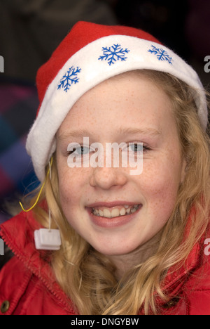 12 ans, fille, wearing christmas hat à un marché de Noël annuel, Petersfield, Hampshire, Royaume-Uni. Banque D'Images