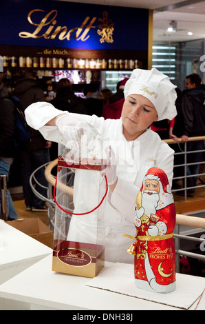 Un employé au chocolat Lindt chocolat enveloppant un Père Noël, le Musée du Chocolat, Cologne, Allemagne, Europe Banque D'Images