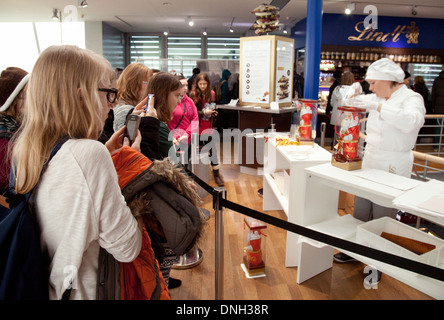 Musée du chocolat de Cologne - visiteurs regardant un employé un emballage Lindt Chocolate Santa Clause, Cologne Allemagne Europe Banque D'Images