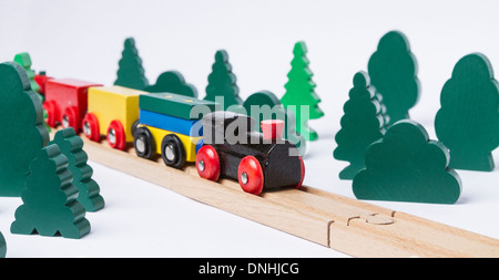 Petit train en bois noir en paysage rural fait avec de simples arbres jouet Banque D'Images