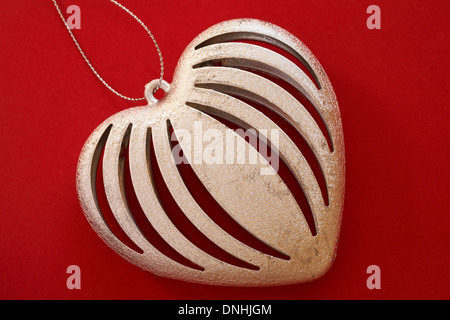 Hanging Heart couleur argent décoration sur fond rouge prêt pour la Saint-Valentin, Jour de Valentines Banque D'Images