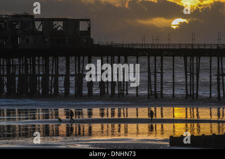 Hastings, Royaume-Uni. Dec 30, 2013. Période de silence entre les tempêtes comme soleil se couche derrière les nuages de pluie à Hastings Pier sur la côte du Sussex de l'Est. La récente tempête a provoqué des inondations dans toute la Grande-Bretagne. Crédit : David Burr/Alamy Live News Banque D'Images