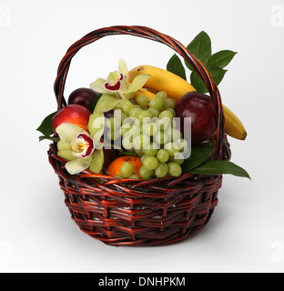 Un panier rempli de fruits assortis sur un fond blanc Banque D'Images