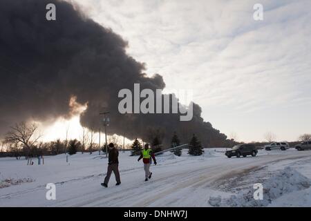 Casselton ont, Dakota du Nord, USA. Dec 30, 2013. Les agents de police de contrôler le trafic à proximité d'un train ont déraillé BNSF brûler juste à l'ouest de Casselton ont. Au moins sept voitures sur les 106 wagon a pris feu après l'accident avec l'explosion de plusieurs boules de feu massive. Crédit : Dave Arntson/ZUMAPRESS.com/Alamy Live News Banque D'Images