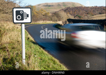 Car on rural Road en passant devant un panneau d'avertissement de radars. , Cumbria (Royaume-Uni) Banque D'Images