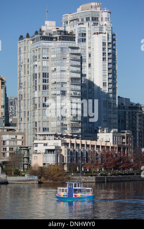 L'île Granville Ferry, vu de False Creek avec de grands bâtiments en arrière-plan. Banque D'Images