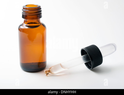 Bouteille en Verre ambré avec compte-gouttes en verre de chute. Fond blanc Banque D'Images