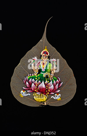 Lakshmi indienne peinte à la main dessin sur une feuille de figuier sacré / arbre de Bodhi feuille sur fond noir Banque D'Images