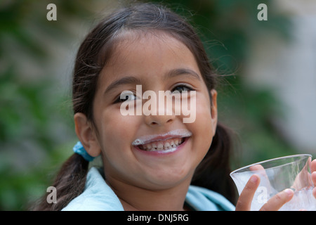 Petite fille est en train de boire un verre de lait Banque D'Images