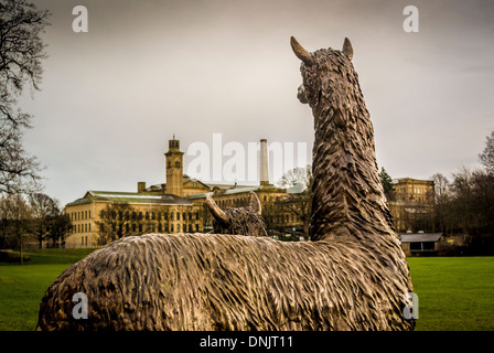 La statue d'Alpacas de Roberts Park vue de derrière avec New Mill et Salts Mill au loin. Saltaire, West Yorkshire. Banque D'Images