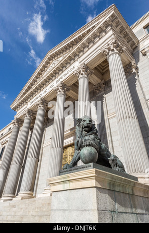 Avis de Congreso de los Diputados (Congrès des députés), Plaza de Las Cortes, Madrid, Espagne avec statue de lion en bronze dans l'entrée et de colonnes sur façade Banque D'Images