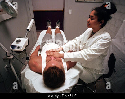 Tampa, Floride, USA. 10 janvier, 2001. Ralguni Khanna (CQ), droit, pratiques Reiki à Matt Wiencek, gauche, au Salon Le Monde sur l'avenue Howard lundi. Selon Khanna, le Reiki est une forme de transfert d'énergie qui a commencé en Inde et a été redécouverte au Japon. Elle est utilisée pour la guérison, la relaxation et le bien-être général. En Reiki, le praticien place ses mains sur les chakras, qui sont au nombre de sept, sur le client. Le praticien transfère ensuite l'énergie dans les chakras. Khanna a été au Salon Le Monde pendant 2 mois et a pratiqué pendant deux ans. (Crédit Image : © Tampa Bay Times/ZUM Banque D'Images