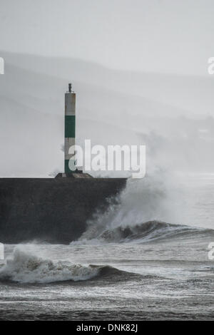 Aberystwyth, Pays de Galles, Royaume-Uni. 1er janvier 2014. Le jour du Nouvel an 2014 le frappeur de vagues de la jetée à Aberystwyth, sur la côte de la Baie de Cardigan, l'ouest du pays de Galles. Encore une autre tempête balaie le système dans de l'Atlantique pour apporter des vents forts, grosses vagues et de la pluie de la côte ouest du Royaume-Uni. Crédit photo : Keith morris/Alamy Live News Banque D'Images