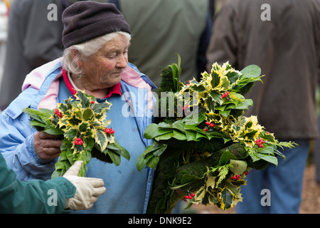 La vente aux enchères annuelle de GUI dans Tenbury, Shropshire. En photo, un acheteur avec des couronnes de houx. Banque D'Images