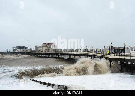 Worthing, UK, 01/01/2014 : mauvais temps le jour du Nouvel An. Un homme regarde les vagues s'écraser sur jetée de Worthing. Photo par Julie Edwards Banque D'Images