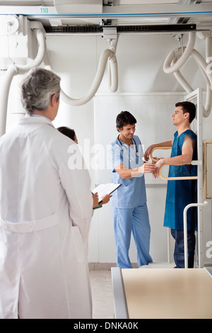 L'équipe médicale avec un patient dans la salle de rayons X. Banque D'Images