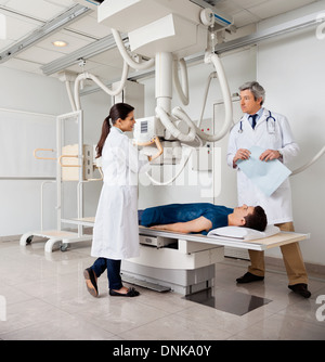 Les radiologues avec patient en salle de radiographie Banque D'Images