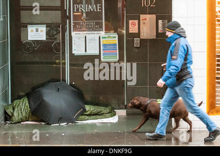 Londres, Royaume-Uni. 06Th Jan, 2014. Un défilé du Nouvel an passe par Piccadilly Circus sur une journée humide et venteux. Dans les rues l'après Noël et Nouvel an tas de déchets et homless personnes sont ignorés par les visiteurs sont chargés par des sacs. London, UK 01 Jan 2014. Crédit : Guy Bell/Alamy Live News Banque D'Images