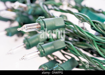 Conduire à des fils rouges sur un brin d'ampoules de Noël Banque D'Images