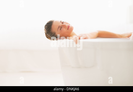 Happy young woman relaxing in bathtub Banque D'Images