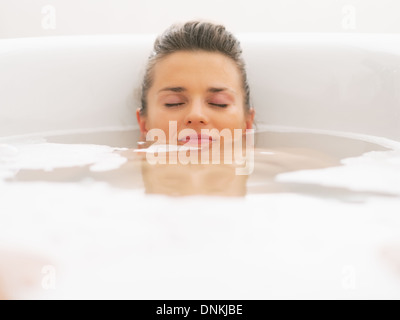 Jeune femme portant sous l'eau dans une baignoire Banque D'Images