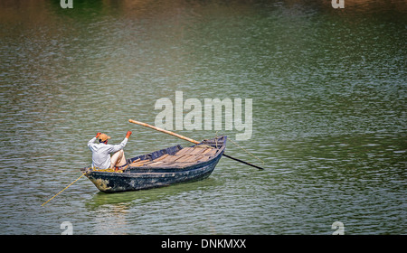 Un pêcheur de l'ouest du Bengale de pêche de Rivière Damodar bateau de son pays en noir et blanc et copy space Banque D'Images