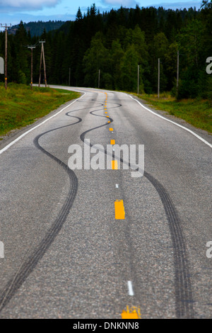 Marques de dérapage en caoutchouc sur la route, traverser la ligne centrale, probablement créé en tant qu'expression de l'ennui par des jeunes Banque D'Images